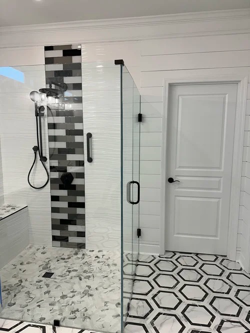 Glass shower enclosure with mosaic tile accent